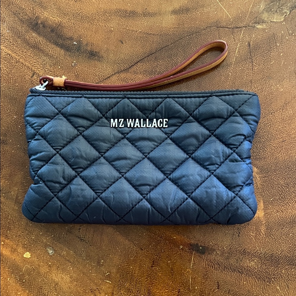 Used, but in great condition.MZ Wallace Navy Quilted Pouch with Brown Strap